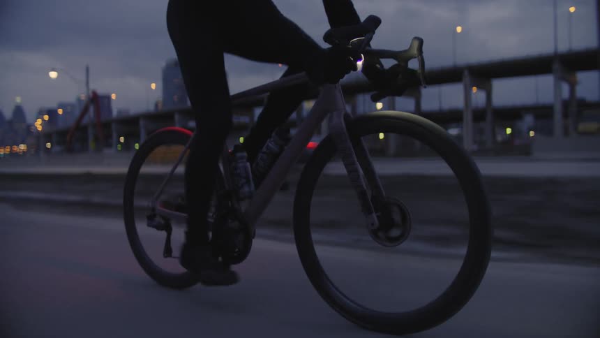Cyclist pedaling on a street on a dark and cloudy morning