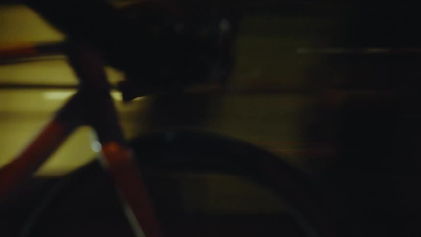 A person riding a bicycle on the city streets at night