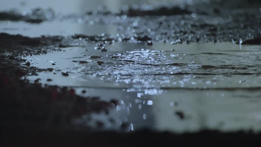 Close up of a splash on a puddle under flashing lights