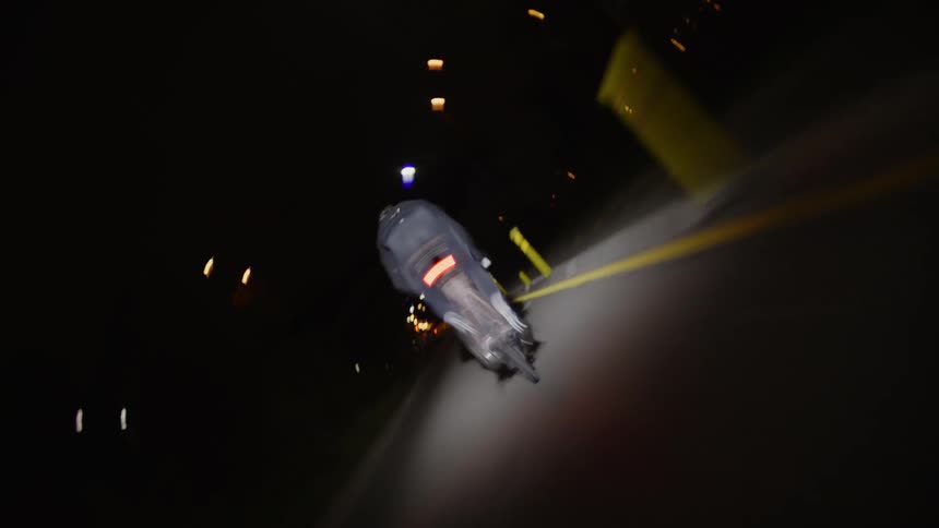 A man is racing his bike on the road at night