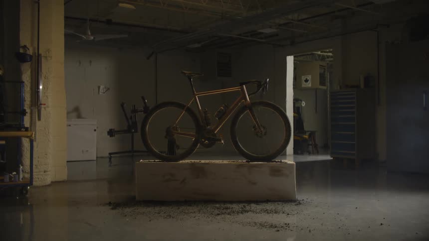 Chrome bicycle inside a room on top of a concrete frame