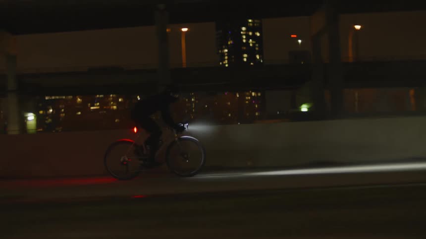 A person riding a bicycle in the city at night