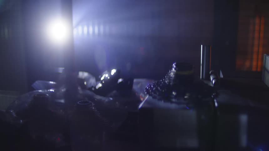 A person searches around the dark room with a flashlight