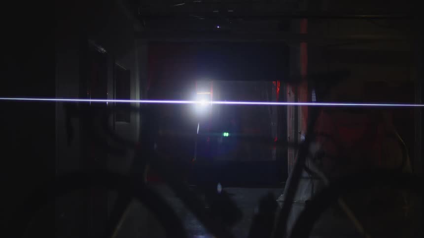 A person walks down the hall with a flashlight