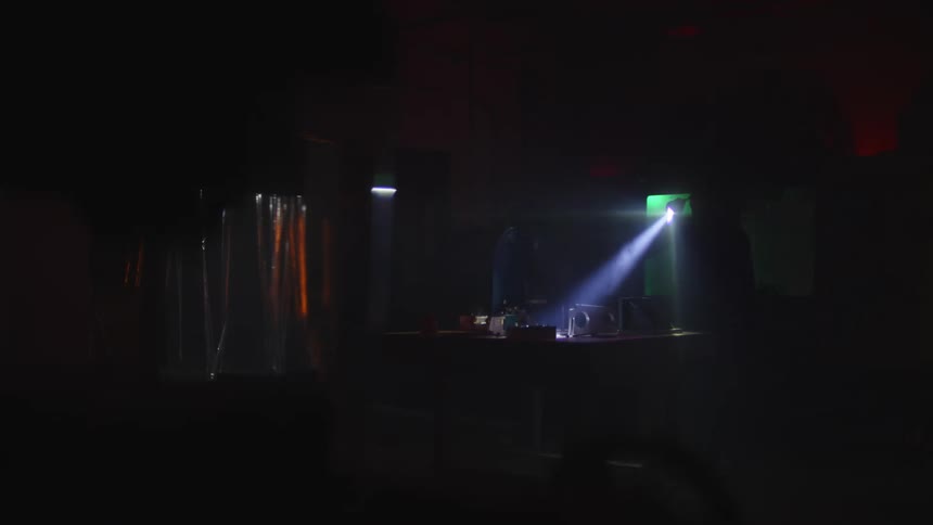 A person is searching around the dark room with a flashlight