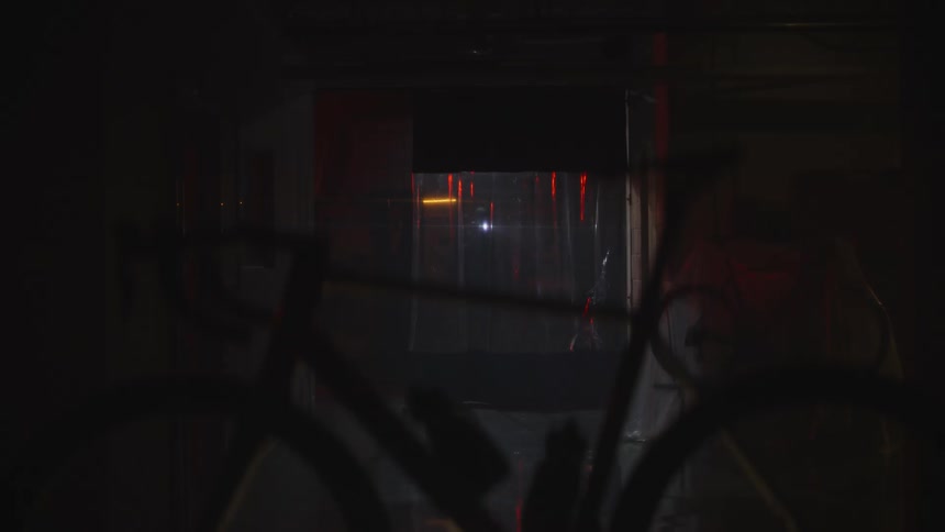 A person looking at a bicycle at night with a flashlight