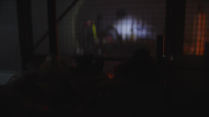 A man in a mask searches around with a flashlight in the dark