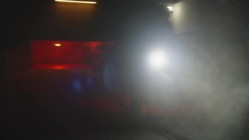 A person riding a motorcycle outdoors at night