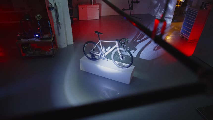 A burglar carrying a flashlight looks at a bicycle on a warehouse