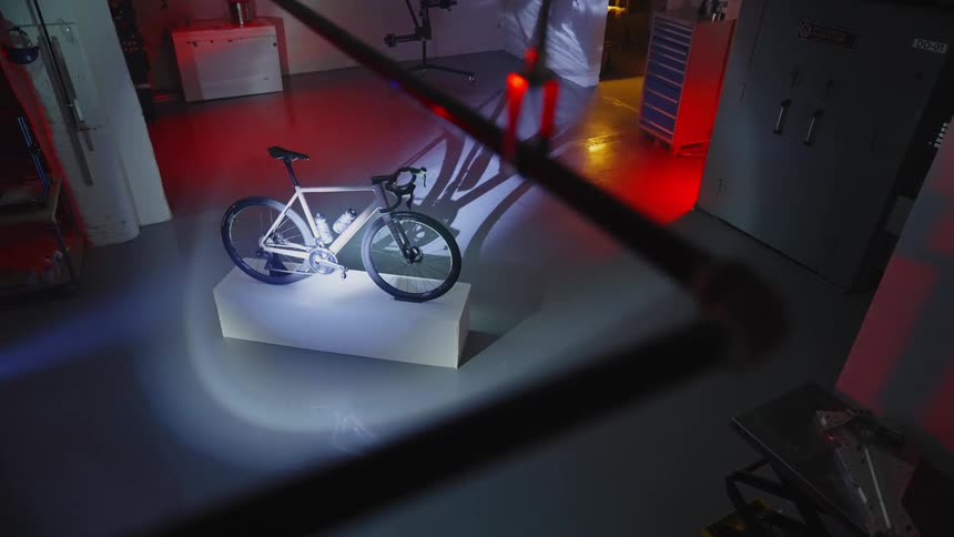 A thief shines a flashlight on a bicycle in the shop