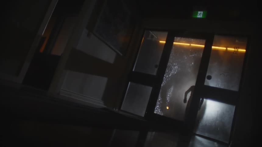 A man breaks into the building by throwing a brick through the glass door