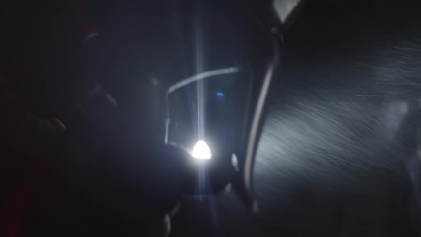 Close up of a person riding a bicycle at night