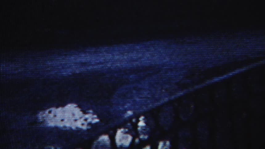 Frame on a screen with a video playing of a bicycle light passing by at night