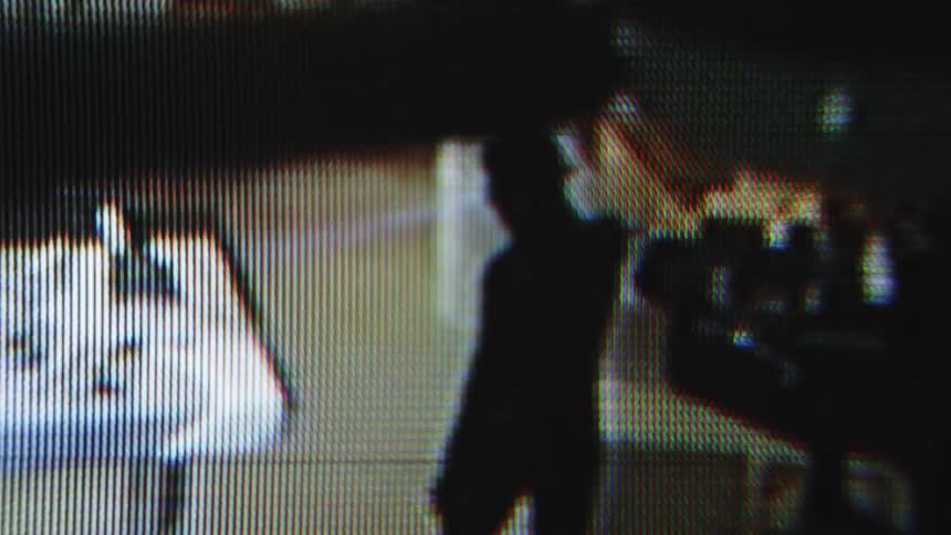 A shadowy person carrying a flashlight caught on video