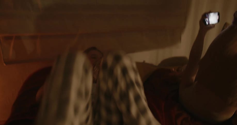Sisters having fun in the bedroom while recording a video with their cell phones