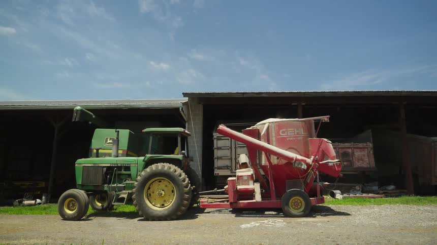 A tractor is in front of the barn