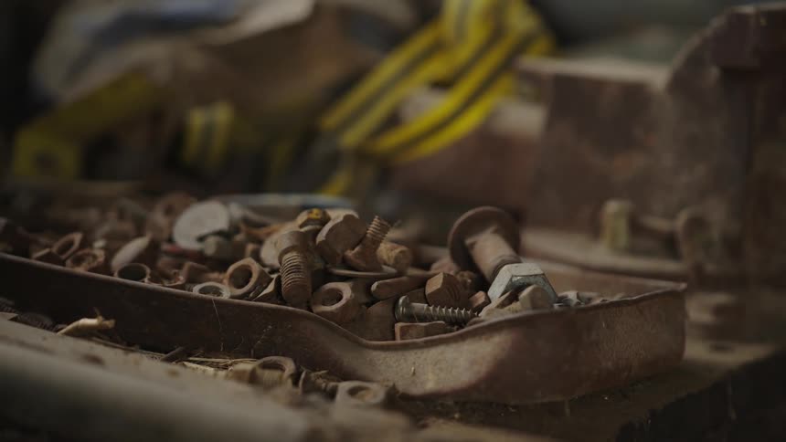 Clusters of rusty screws on top of a metal