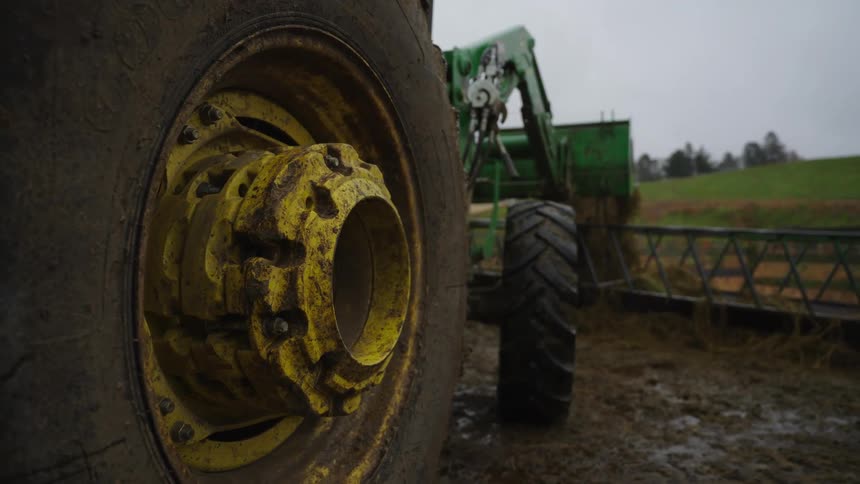 Side view of a tractor and a post with clay on a cloudy day
