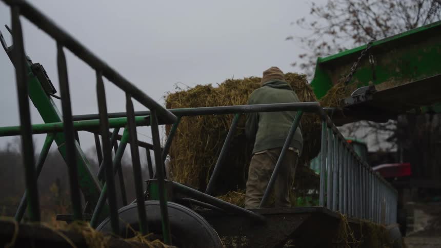 Man inside a bucket removing a block of grass