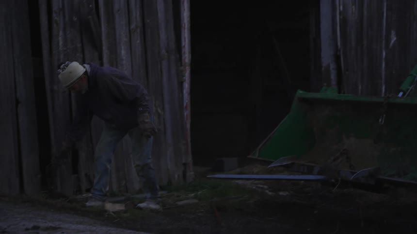 A man working on his property beside the tractor