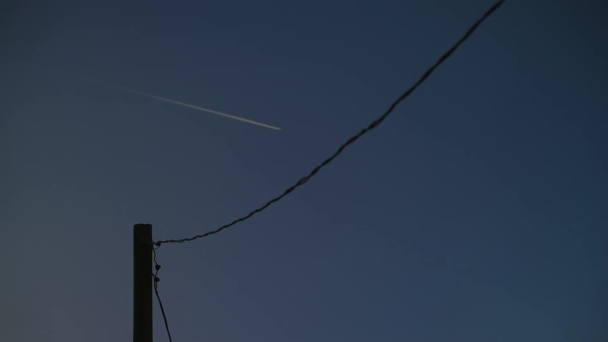A plane flying overhead at dusk