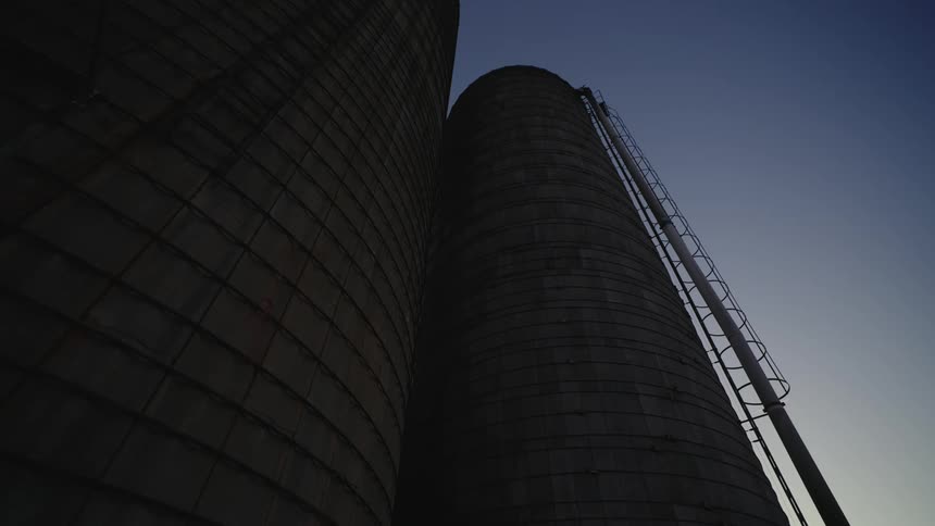 Two huge grain storage platforms in a morning sky