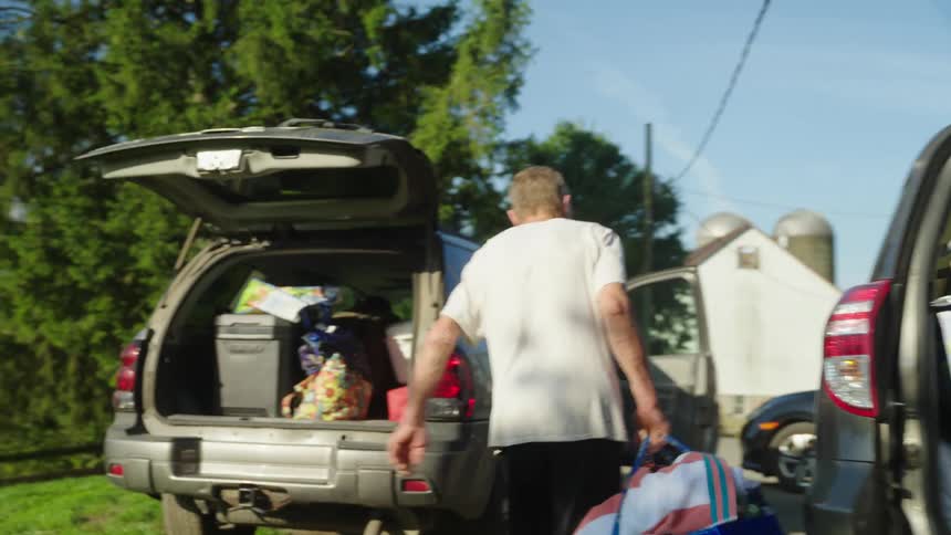 Two men are packing the vehicles for a trip