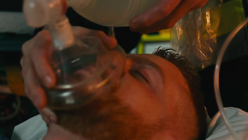 A man on a stretcher is giving oxygen by the emergency technician