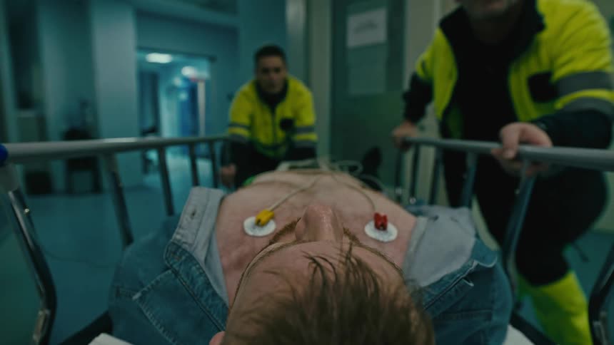 Rescue teams transport a patient in a bed through the hospital corridors