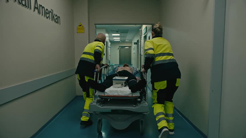 Emergency technicians race a stretcher down the hospital hall