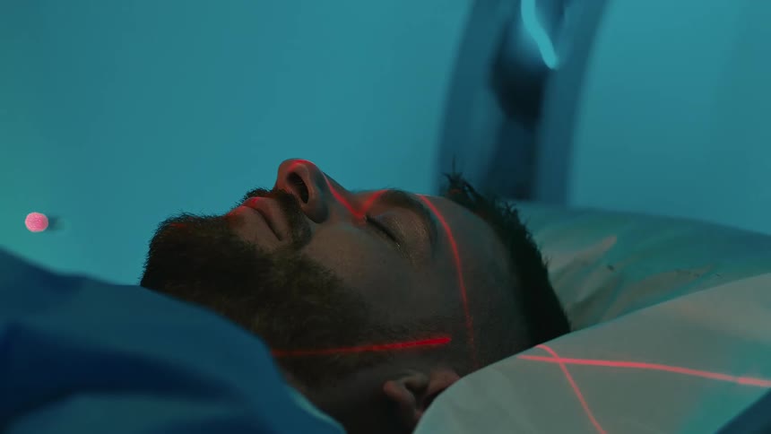 Man sleeping and entering an mri magnetic resonance imaging machine