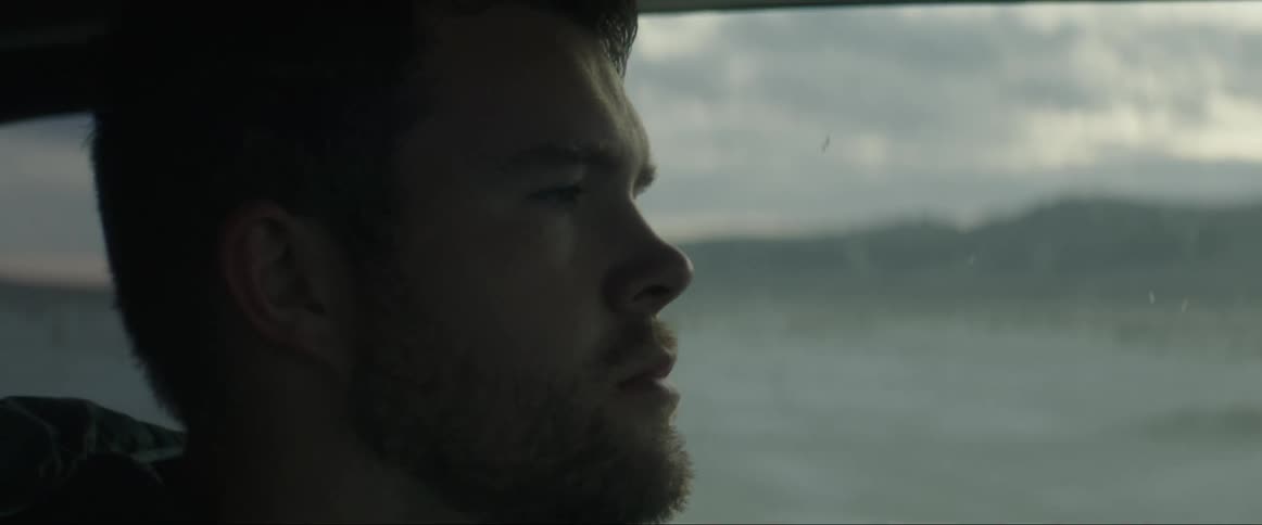A man driving a vehicle by the country side at sunset