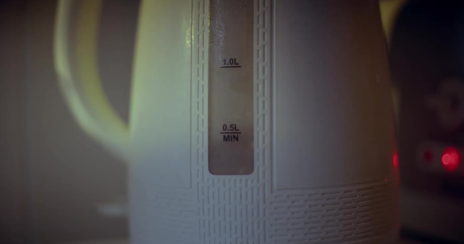 A closeup of a white electric kettle with a water level