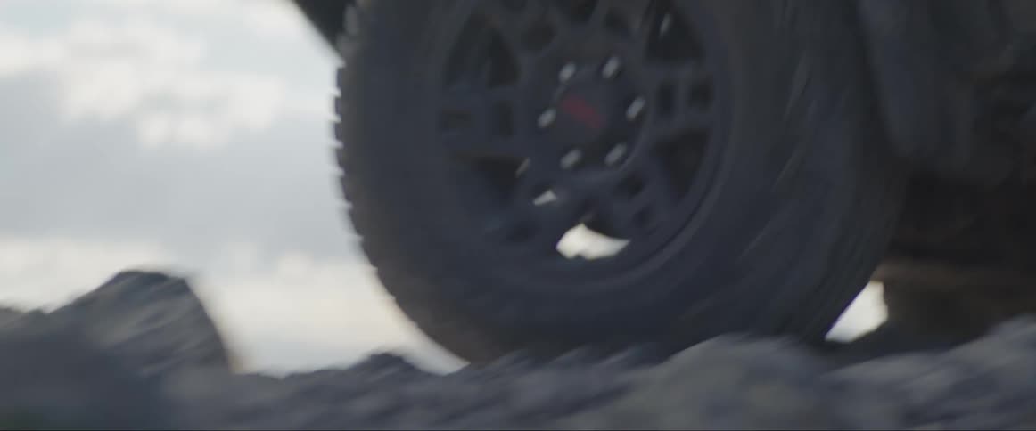 A vehicle drives over an extremely rocky terrain