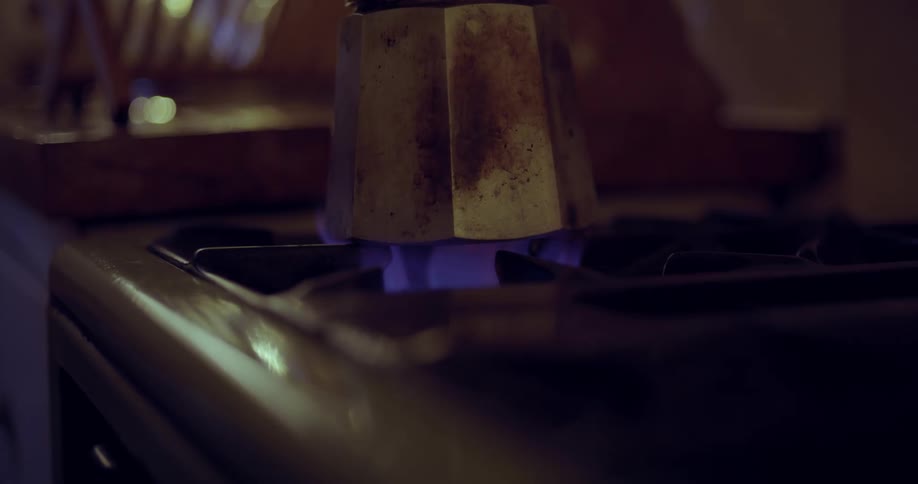 Old style Italian coffee percolator is placed on a gas stove