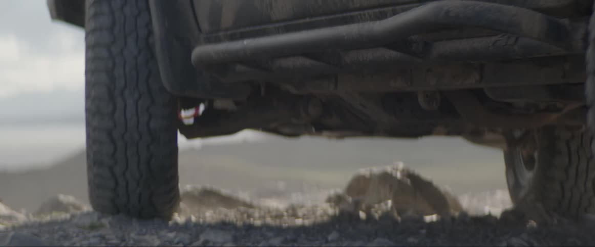 Wheels of a sports truck descending a hill in the middle of the desert