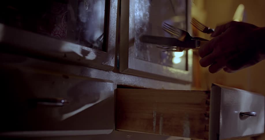 Hands opening a drawer and taking out cutlery