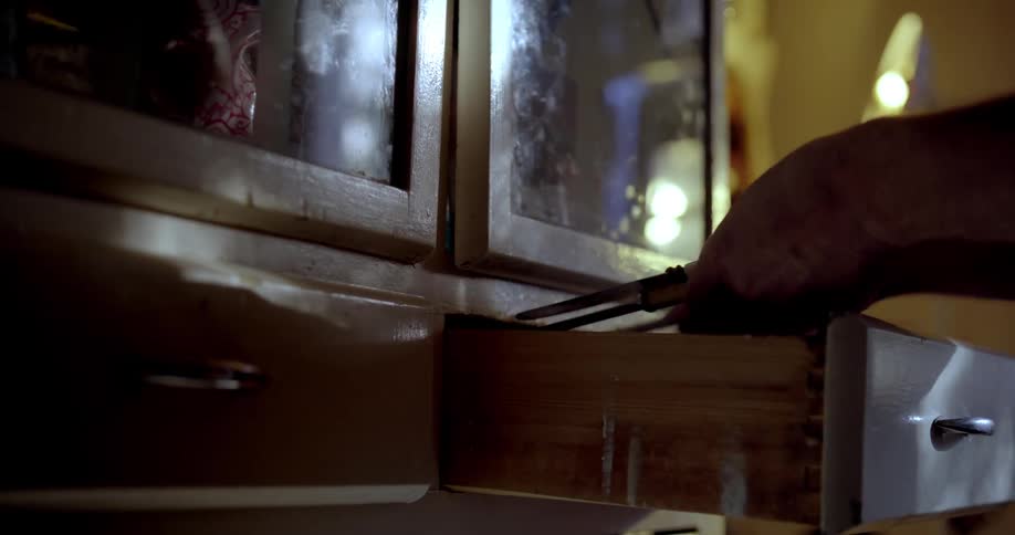 Hands of a man opening a drawer and taking out cutlery