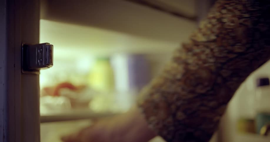 Close up of a person opening an old fashioned refrigerator and grabbing a plastic milk container