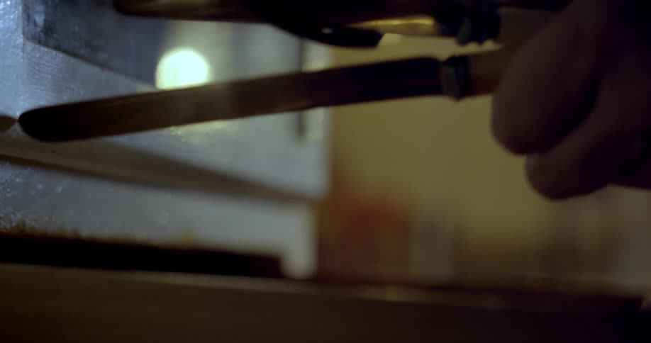 A close up of a person taking cutlery from a draw