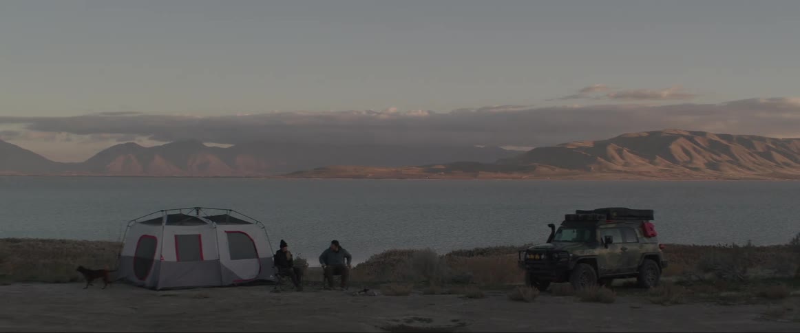 Two men camping by a body of water