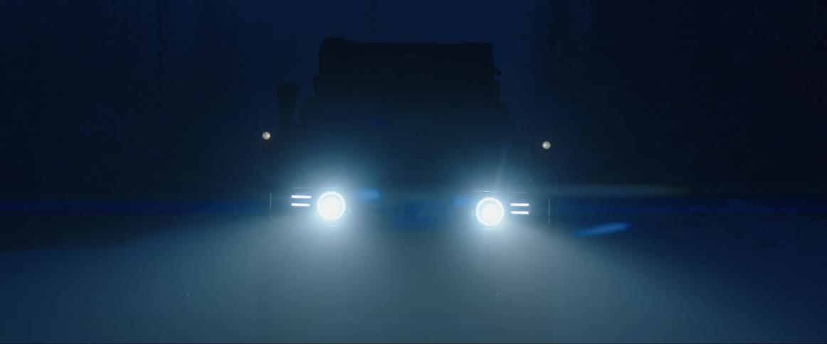 A foggy night with a car and its headlights on