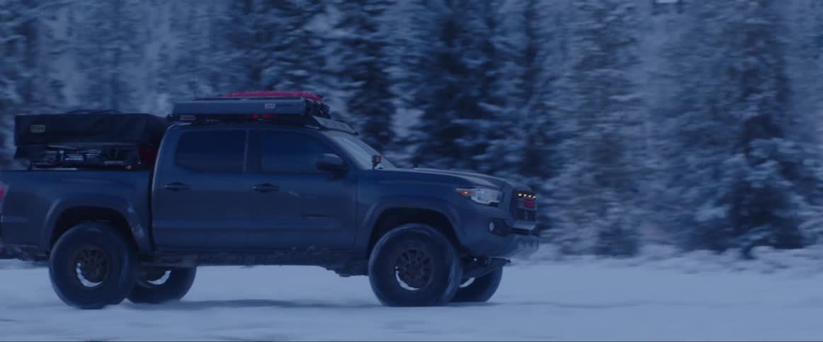 Truck driving through a snowcovered forest floor and braking