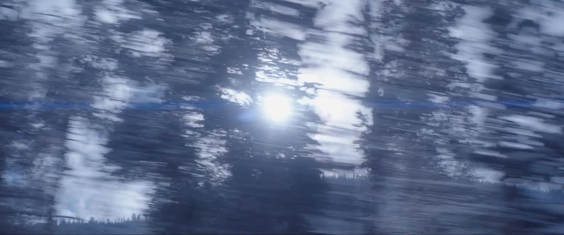 Time laps drive in the woods perspective of the sun over a mountain hillside glaring through a blur of silhouetted trees in the winter