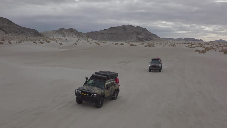 Aerial view of two offroad vehicles driving in the desert