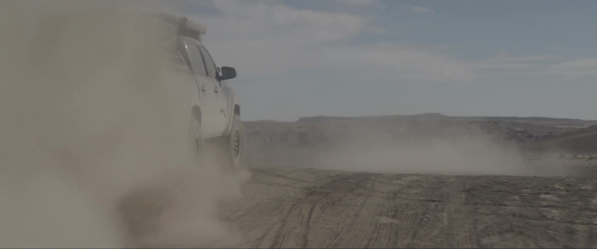 Pickup truck running fast on a sandy road during the day
