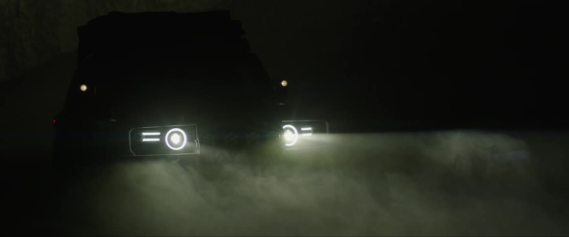 Vehicle turning on lights at night in a dark sawdusted place