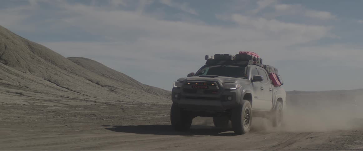 Pickup truck moving on a sandy road on a sunny day