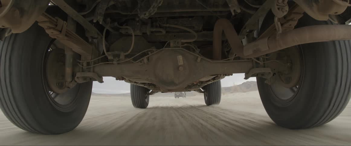 The underside of an offroad vehicle moving fast on the desert