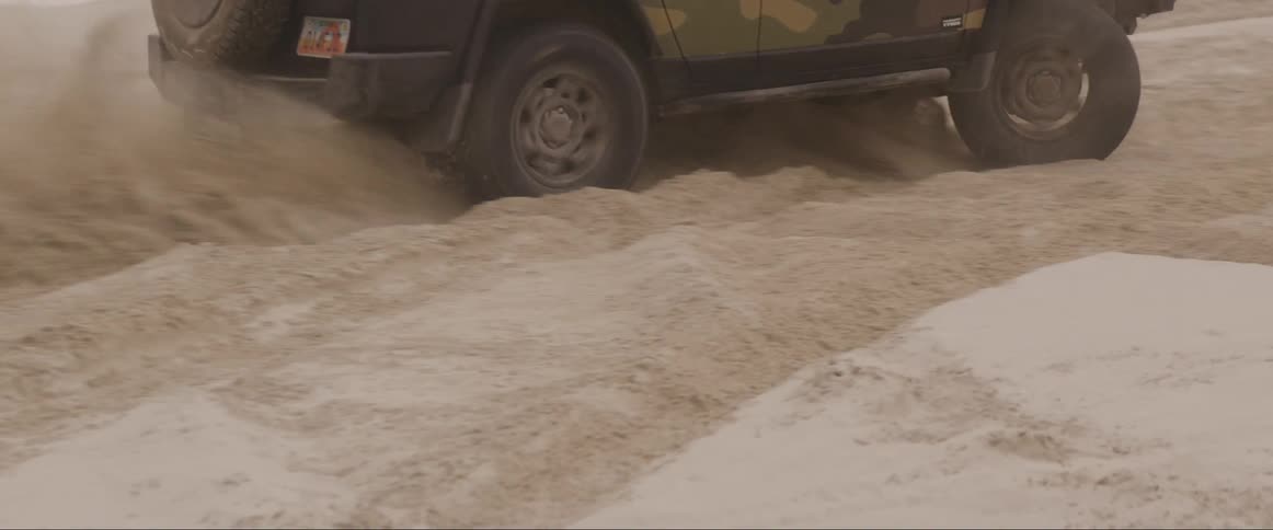 Jeep driving in a circle in the middle of a sand dune